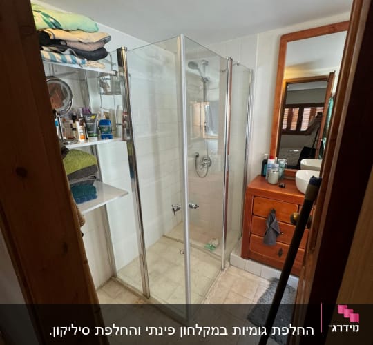 מקלחון זכוכית עם ראש מקלחת ומדף מגבות